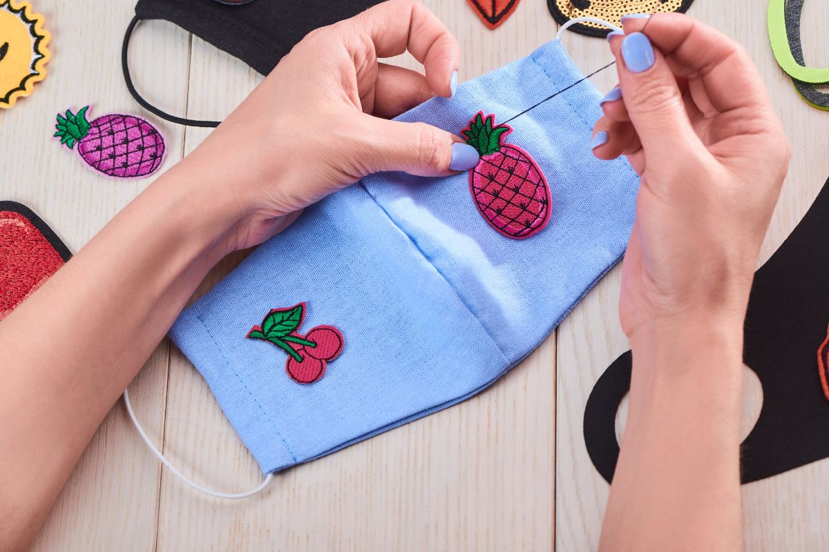 A-woman-is-sewing-a-patches-onto-a-mask